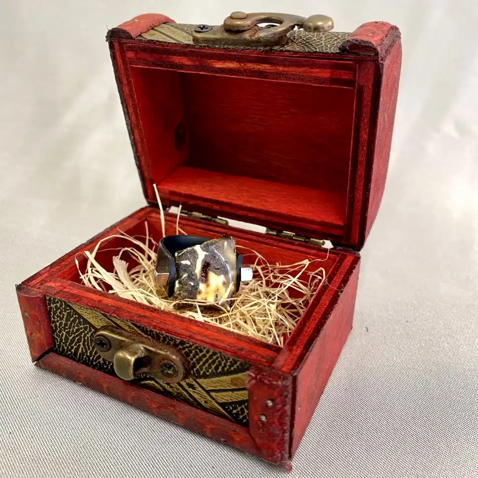 Vibrant red wooden jewelry box with an exquisite ring, showcasing vintage and modern design elements.