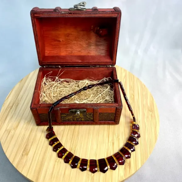 Amber gemstone necklace in antique wooden box, showcasing exquisite craftsmanship and elegant design.