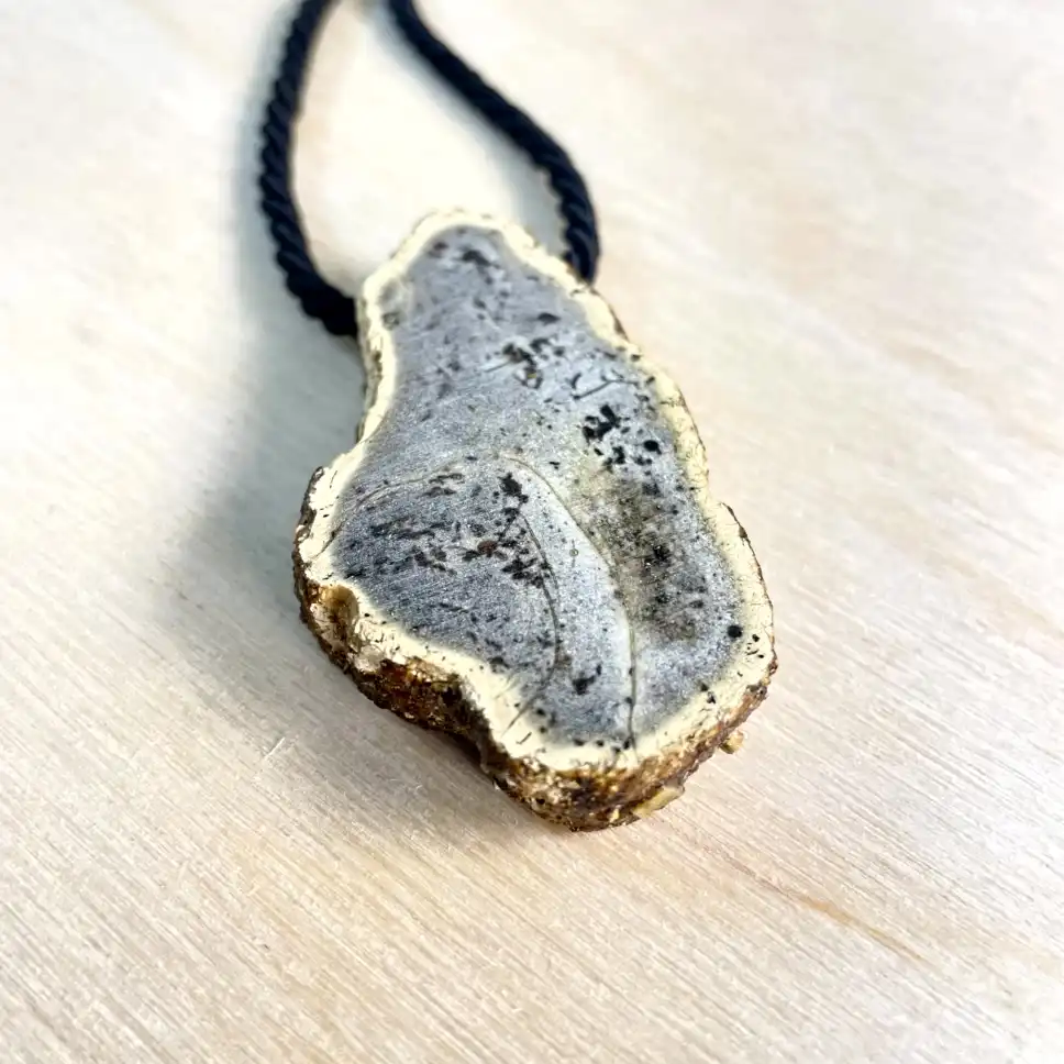 Unique amber chunk necklace on a braided cord, showcasing earthy tones and elegant gold accents.