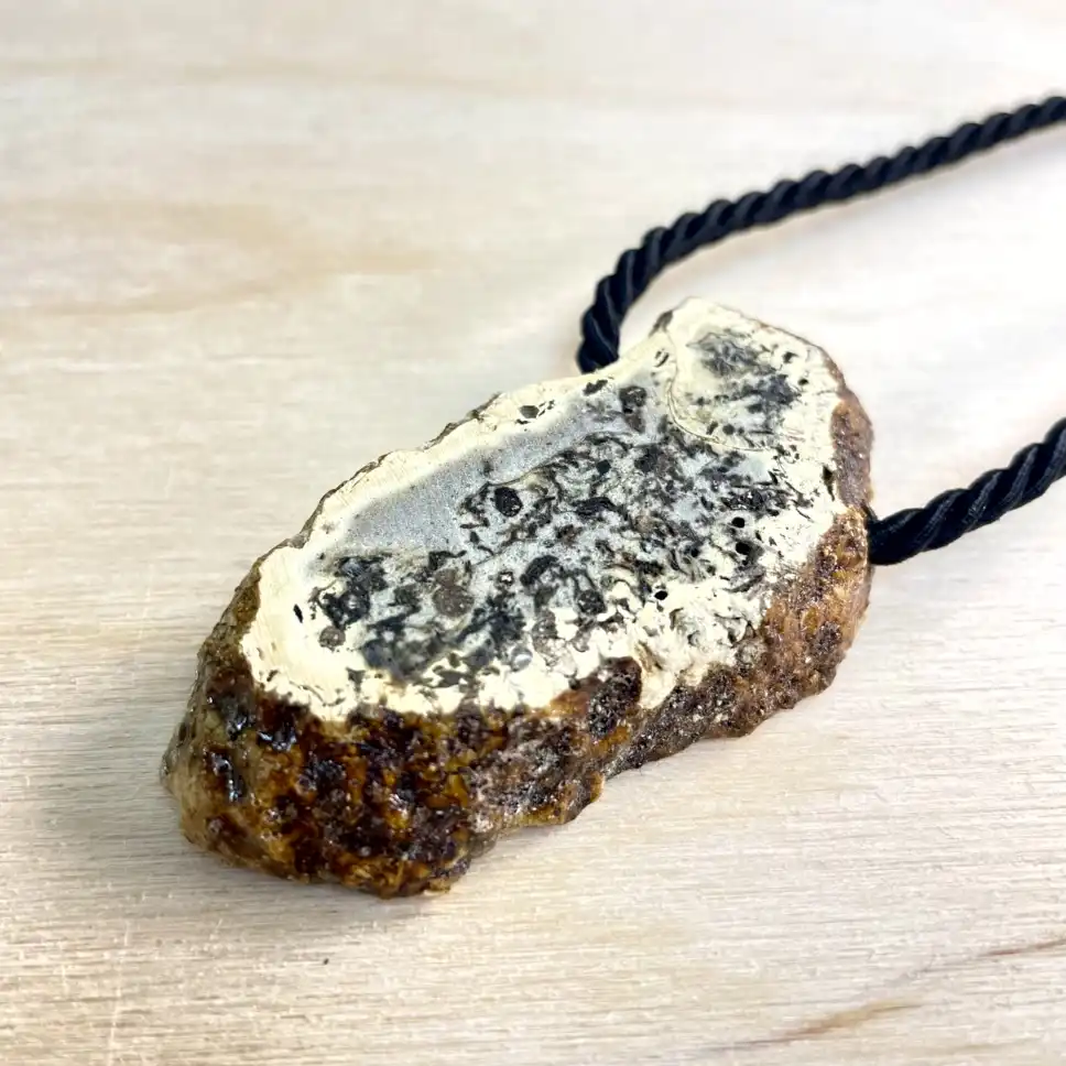 Unique amber chunk necklace on black rope chain, showcasing natural textures and earthy tones.