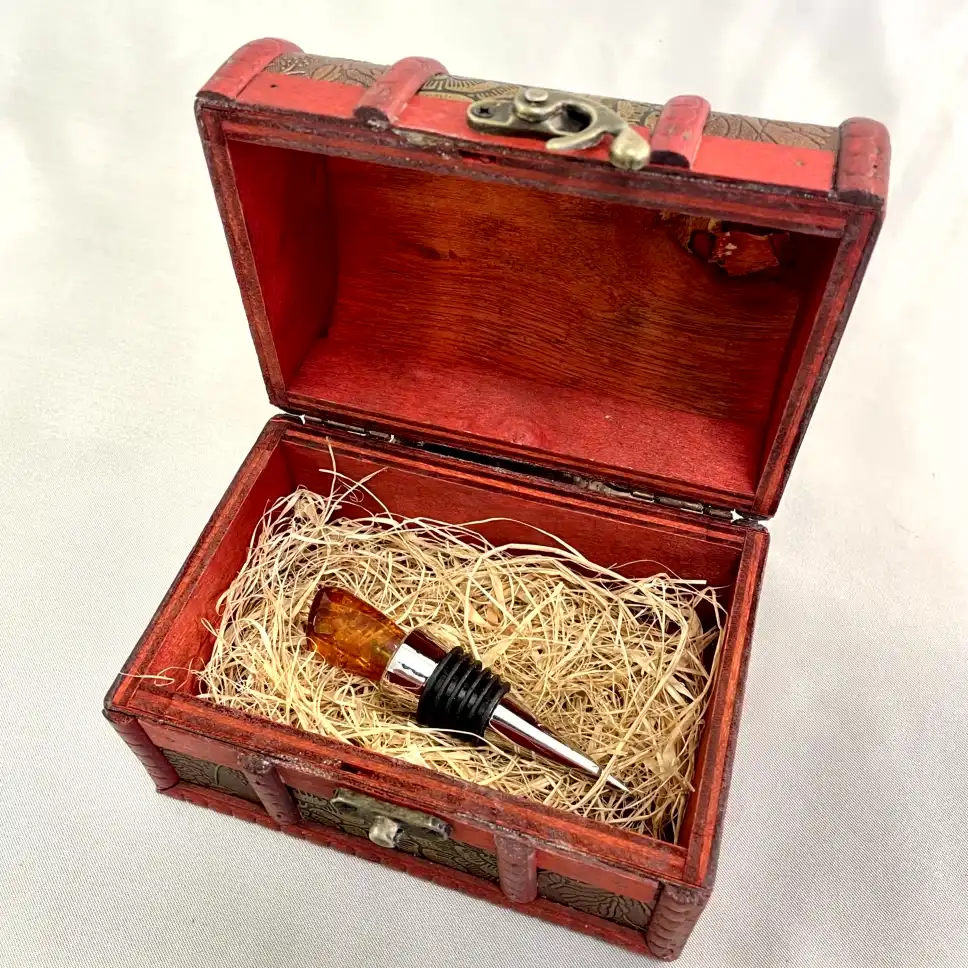Vintage red wooden chest with elegant wine stopper, perfect for gifts or collectibles.