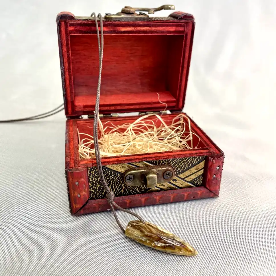 Charming wooden box with vibrant red finish and decorative arrowhead pendant for keepsakes.