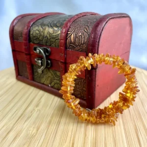 Amber bracelet and vintage treasure chest create a harmonious blend of nature and craftsmanship.