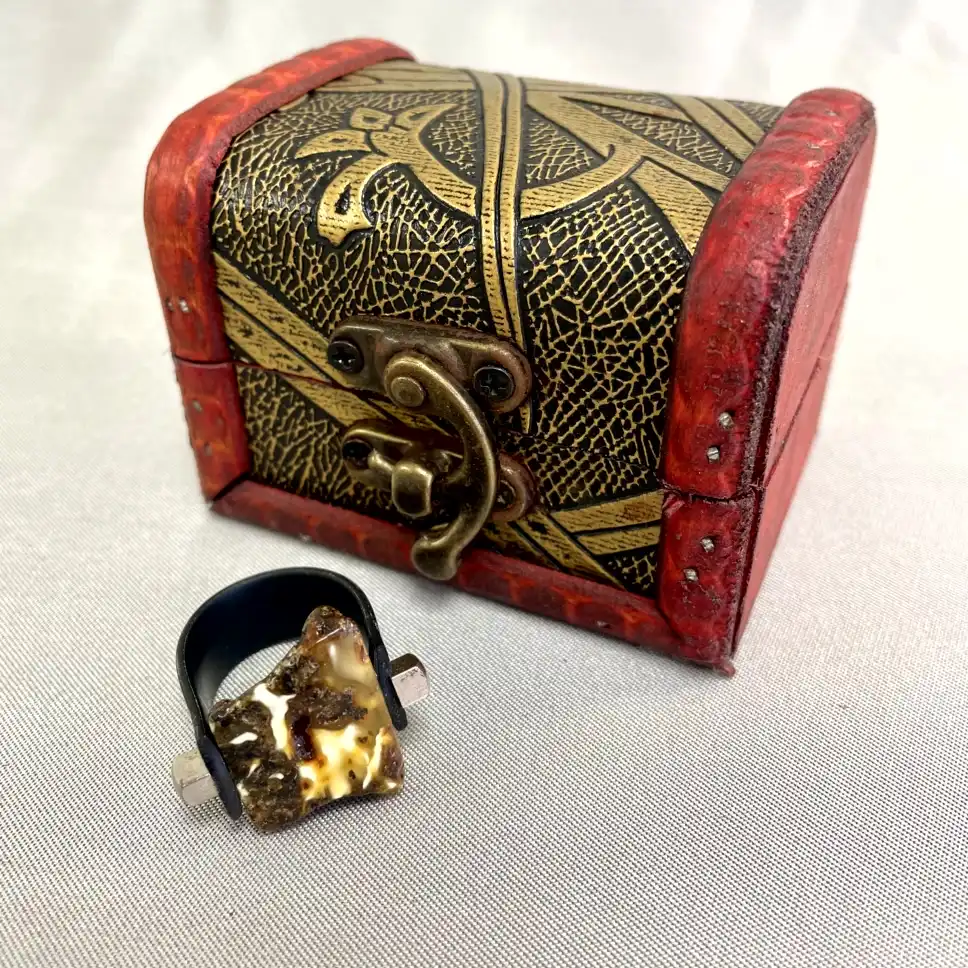 Vintage treasure chest and unique ring with earthy gemstone, evoking adventure and mystery.