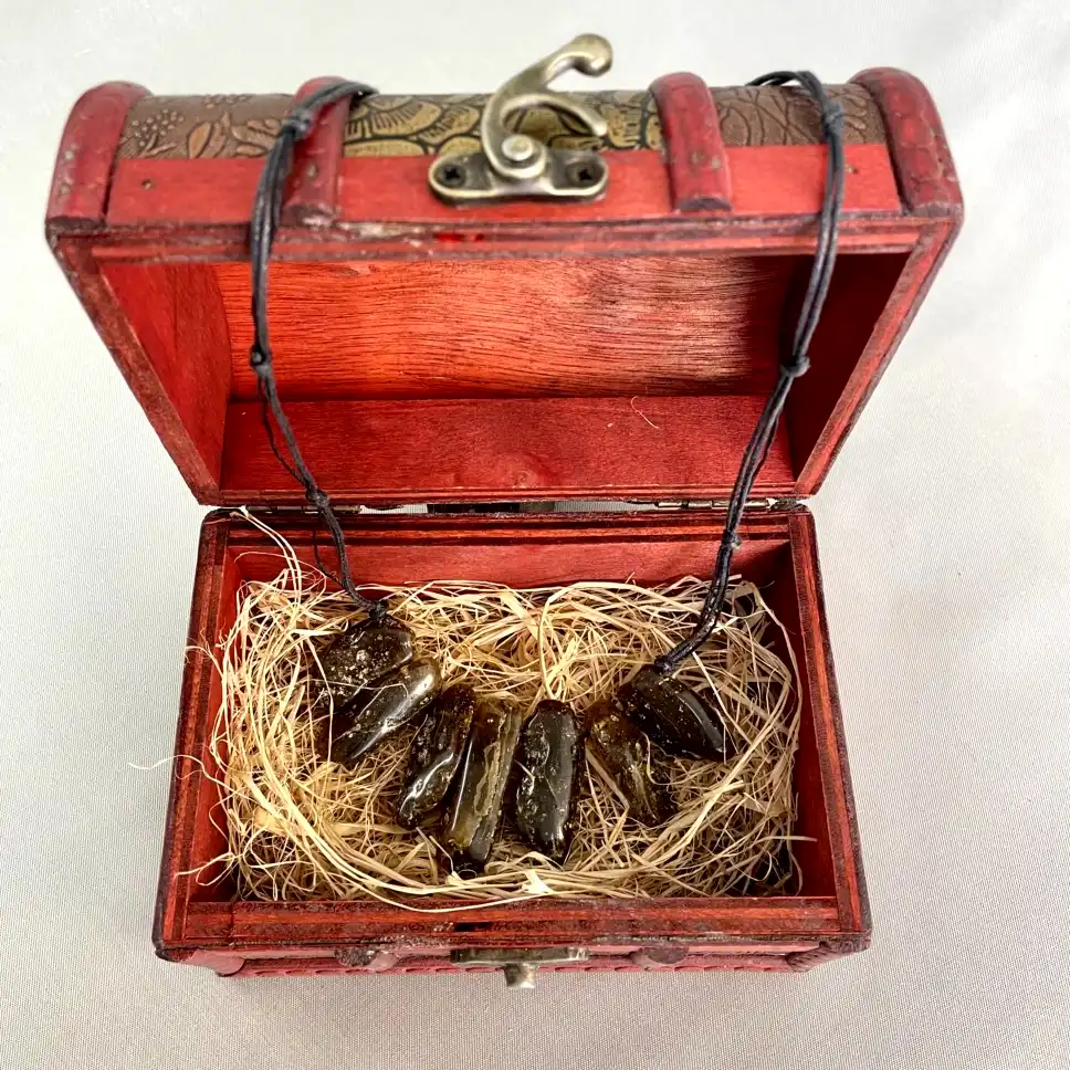 Charming wooden jewelry box with dark obsidian stones neatly arranged for a beautiful necklace display.