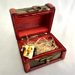 Intricate vintage wooden treasure chest containing a delicate brooch, exuding charm and nostalgia.