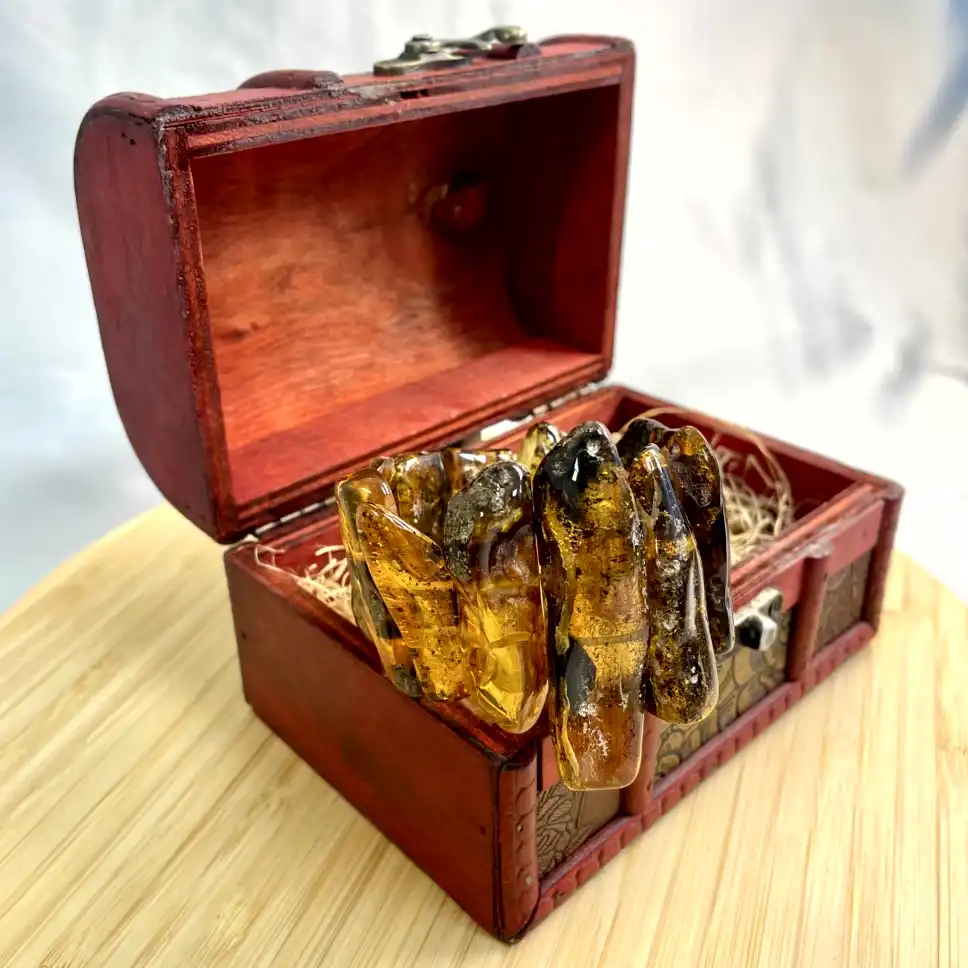 Intricately carved wooden chest filled with amber resin crystals, exuding elegance and mystery.